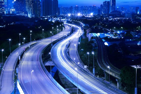 Blue tinted time lapse photo of urban highways at night.
